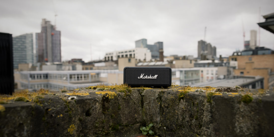 Der Marshall Emberton, ein Bluetooth-Lautsprecher auf einer Mauer vor einer Skyline.