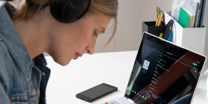 Eine junge Frau nutzt Spotify Connect auf ihrem Laptop.