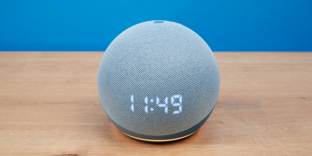 Amazon Echo Dot mit Uhr vor blauem Hintergrund