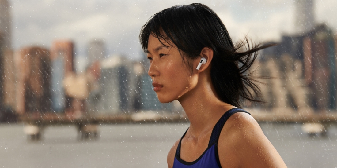 Frau joggt im Regen mit Apple AirPods (3. Generation)