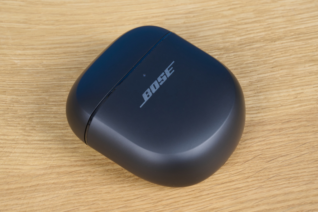 Ladecase der Bose QuietComfort Ultra Earbuds auf Holztisch
