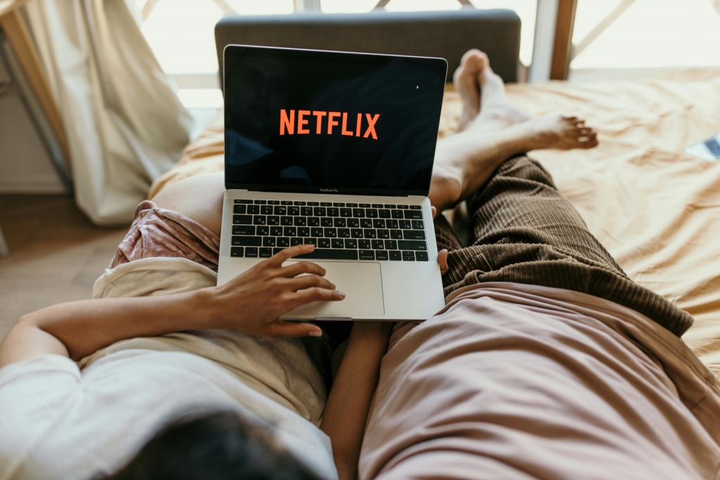 Paar mit Netflix auf dem Laptop im Bett