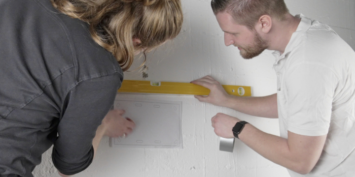 Zwei Personen montieren eine TV-Wandhalterung -Diese Fehler solltest du vermeiden.