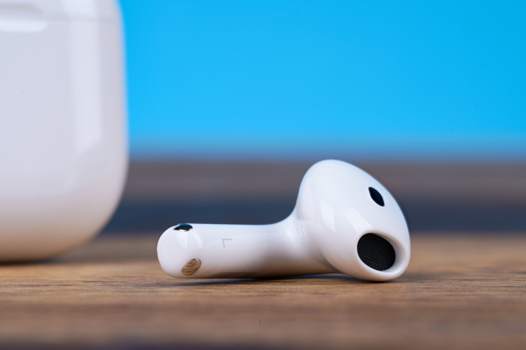 Apple AirPods 5 mit kabellosem Ladecase – Buds neben dem Case